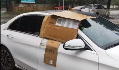 太暖了！车停在路边忘关窗 好心人帮他用纸箱挡雨~